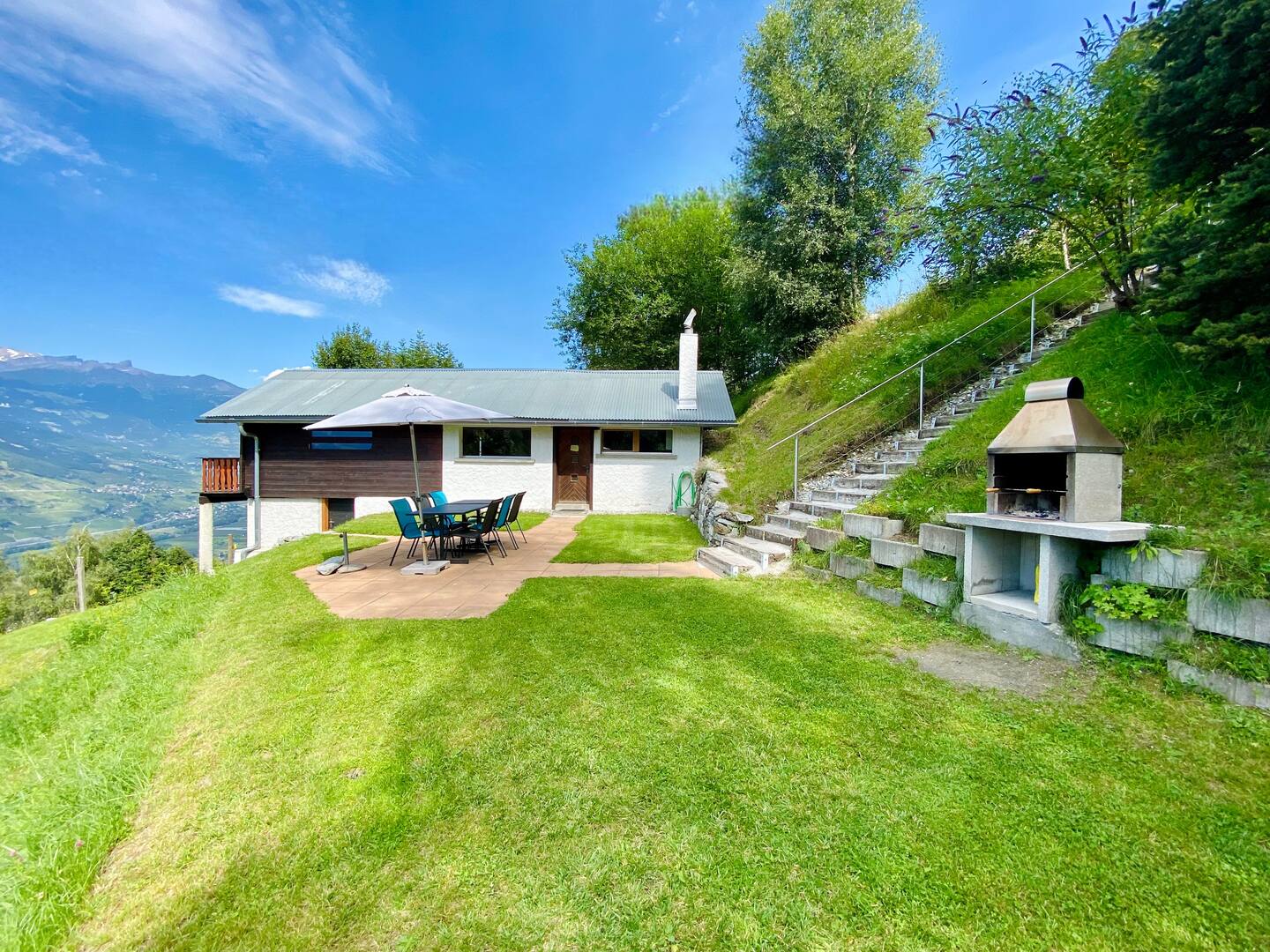 Chalet avec jardin, terrasse et barbecue en pierre face à la vallée