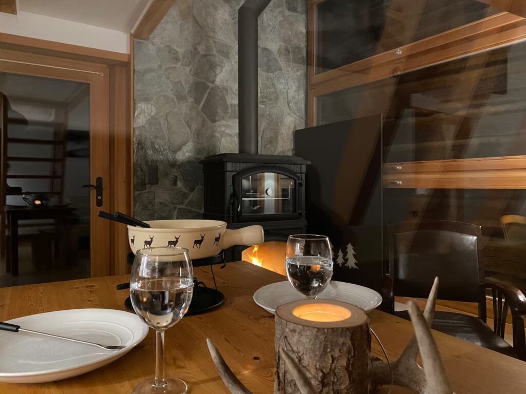 Table set for fondue by the stove at Le Raccard de Louise