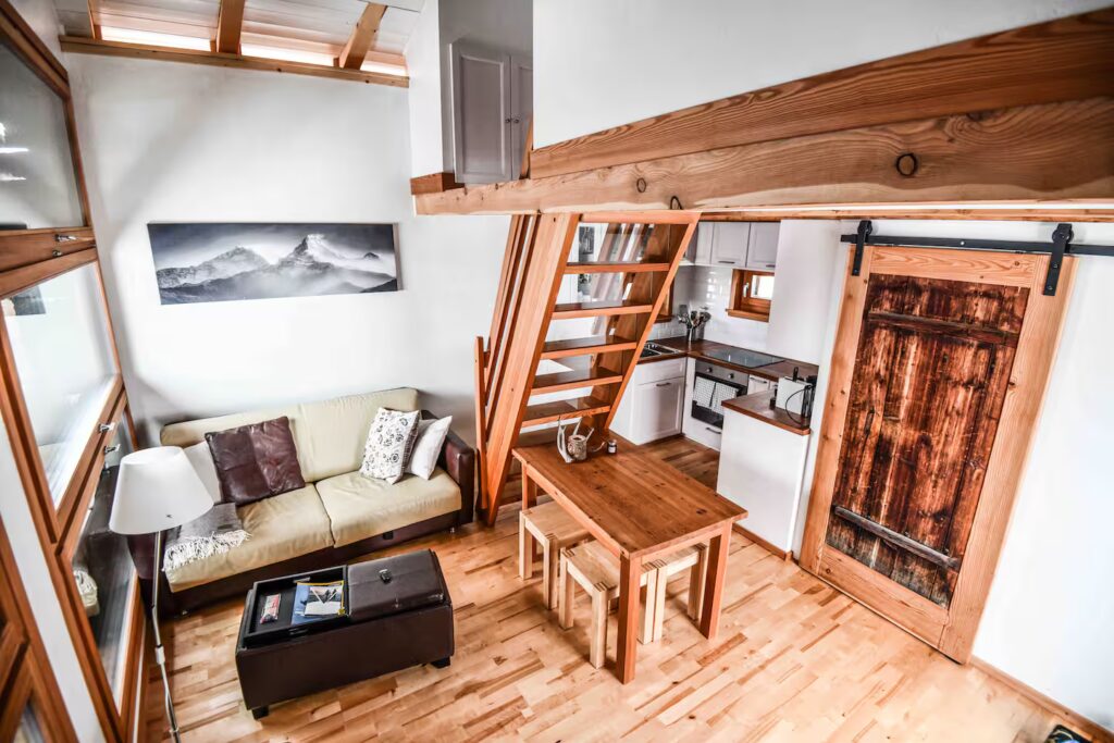 Living room with sofa and antique door at Le Raccard de Louise