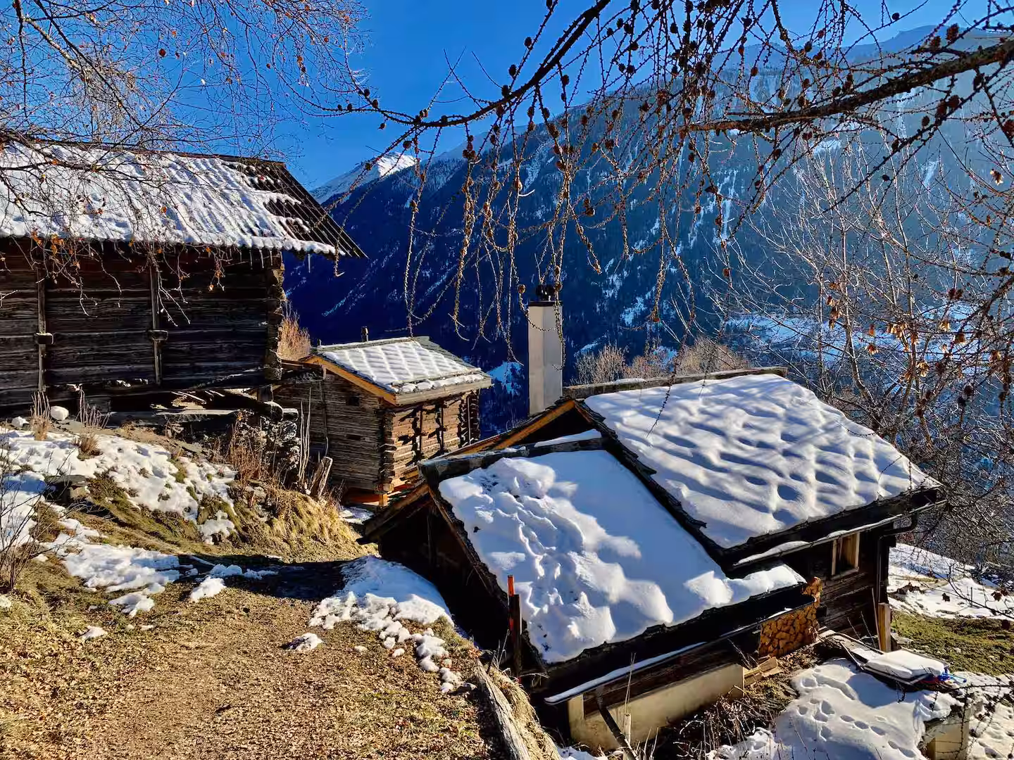 Raccards enneigés à flanc de montagne dans le val d’Hérens