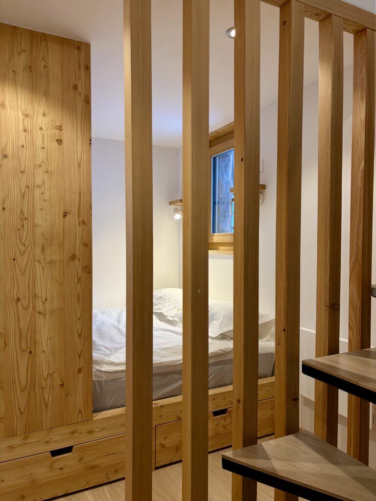 Chambre derrière une claustra en bois au Grenier d’Isabelle